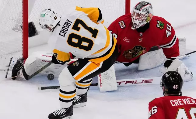 Chicago Blackhawks goaltender Arvid Soderblom (40) saves a shot by Pittsburgh Penguins center Sidney Crosby (87) during the second period of an NHL hockey game in Chicago, Sunday, Dec. 28, 2025. (AP Photo/Nam Y. Huh)