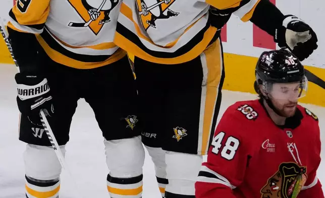 Pittsburgh Penguins right wing Justin Brazeau (16) celebrates with right wing Anthony Mantha (39) after scoring during the first period of an NHL hockey game against the Chicago Blackhawks in Chicago, Sunday, Dec. 28, 2025. (AP Photo/Nam Y. Huh)