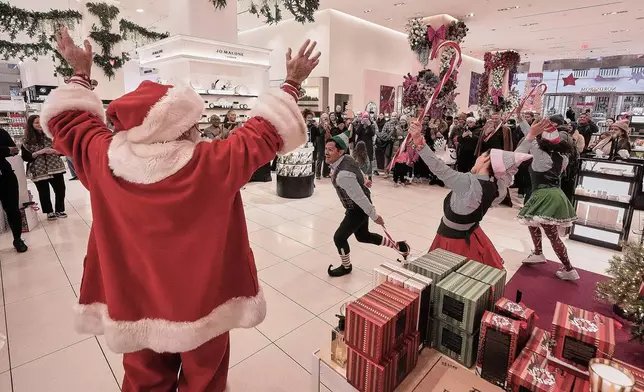 People portraying Santa and his elves perform in the cosmetics department at a Nordstrom department store, in New York, Monday, Dec. 8, 2025. (AP Photo/Richard Drew)