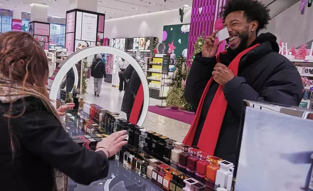Ivan Leon chooses from Tom Ford fragrances at a Nordstrom department store, in New York, Monday, Dec. 8, 2025. (AP Photo/Richard Drew)