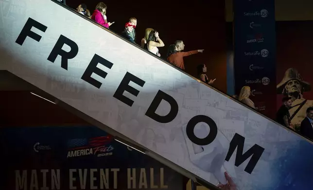 Attendees ride an escalator into the main hall during Turning Point USA's AmericaFest 2025, Thursday, Dec. 18, 2025, in Phoenix. (AP Photo/Jon Cherry)