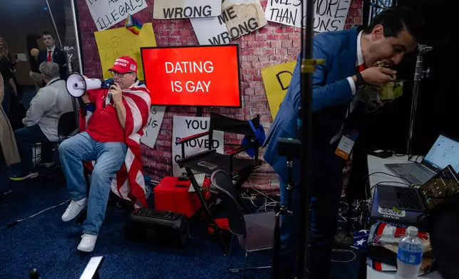 A right-wing podcaster speaks with attendees during Turning Point USA's AmericaFest 2025, Thursday, Dec. 18, 2025, in Phoenix. (AP Photo/Jon Cherry)