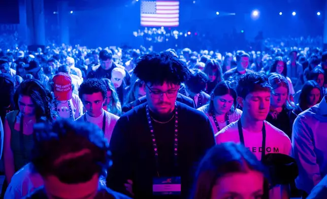 Attendees pray during Turning Point USA's AmericaFest 2025, Thursday, Dec. 18, 2025, in Phoenix. (AP Photo/Jon Cherry)