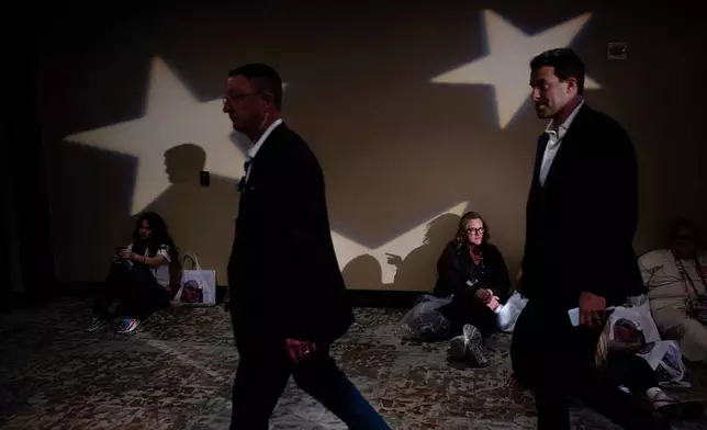 Attendees sit on the floor during Turning Point USA's AmericaFest 2025, Thursday, Dec. 18, 2025, in Phoenix. (AP Photo/Jon Cherry)