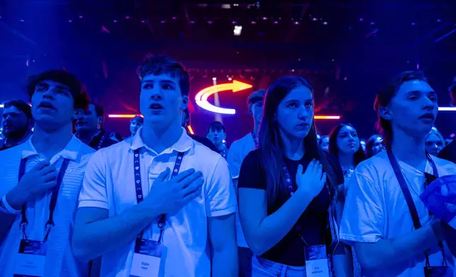 Attendees stand during Turning Point USA's AmericaFest 2025, Thursday, Dec. 18, 2025, in Phoenix. (AP Photo/Jon Cherry)