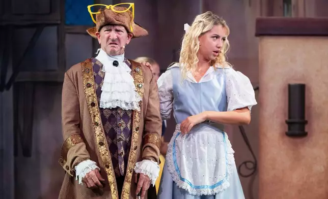 Michael Edwards, better known as Eddie the Eagle, plays Professor Crackpot, as he performs with fellow actors in the pantomime "Beauty and the Beast" at Watersmeet Theatre, in Rickmansworth, England, Dec. 5, 2025. (AP Photo/Thomas Krych)