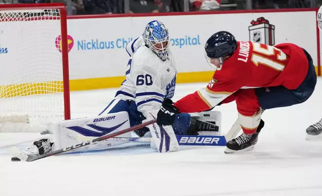 Toronto Maple Leafs goaltender Joseph Woll (60) defends the goal against Florida Panthers center Anton Lundell (15) during the second period of an NHL hockey game, Tuesday, Dec. 2, 2025, in Sunrise, Fla. (AP Photo/Lynne Sladky)