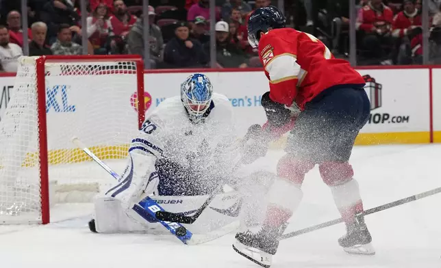 Toronto Maple Leafs goaltender Joseph Woll (60) defends the goal against Florida Panthers center Luke Kunin, right, during the second period of an NHL hockey game, Tuesday, Dec. 2, 2025, in Sunrise, Fla. (AP Photo/Lynne Sladky)