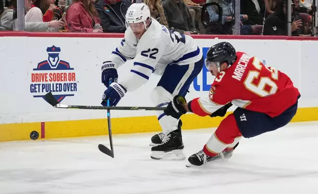 Toronto Maple Leafs defenseman Jake McCabe (22) and Florida Panthers left wing Brad Marchand (63) chase the puck during the second period of an NHL hockey game, Tuesday, Dec. 2, 2025, in Sunrise, Fla. (AP Photo/Lynne Sladky)
