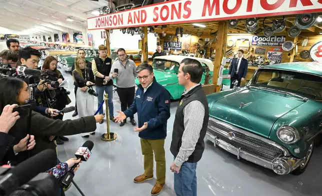 U.S. House Speaker Mike Johnson speaks to the media as he stumps for Republican U.S Congressional candidate for the seventh district Matt Van Epps, right, during a rally inside a supporter's garage featuring a classic car collection Monday, Dec. 1, 2025, in Franklin, Tenn. (AP Photo/John Amis)