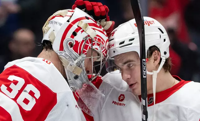 Detroit Red Wings goaltender John Gibson (36) and Axel Sandin-Pellikka (44) celebrate after defeating the Vancouver Canucks during an NHL hockey game in Vancouver, B.C., Monday, Dec. 8, 2025. (Ethan Cairns/The Canadian Press via AP)