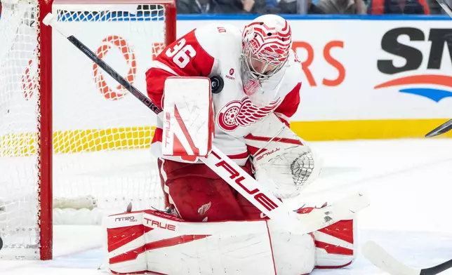 Detroit Red Wings goaltender John Gibson (36) stops the puck against the Vancouver Canucks during the third period of an NHL hockey game in Vancouver, B.C., Monday, Dec. 8, 2025. (Ethan Cairns/The Canadian Press via AP)