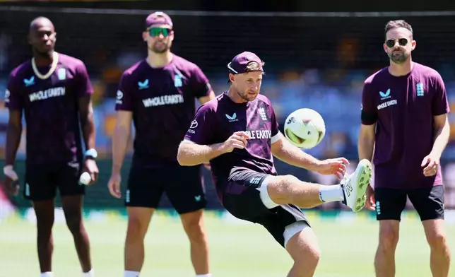 England's Joe Root, centre, with team mates warms up before start the second day of the second Ashes cricket test match between Australia and England in Brisbane, Friday, Dec. 5, 2025.. (AP Photo/Tertius Pickard)