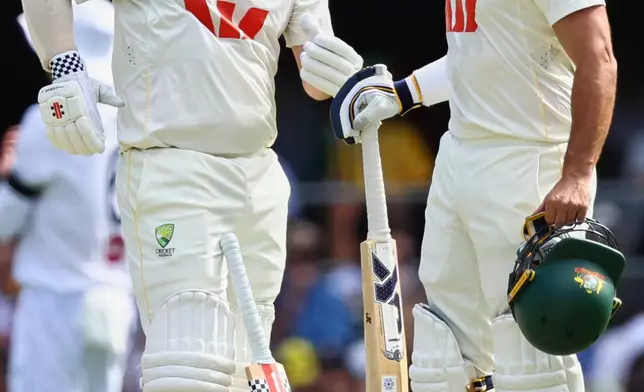 Australia's Travis Head, left, talks to Australia's Jake Weatherald during the second Ashes cricket test match between Australia and England in Brisbane, Friday, Dec. 5, 2025.. (AP Photo/Tertius Pickard)