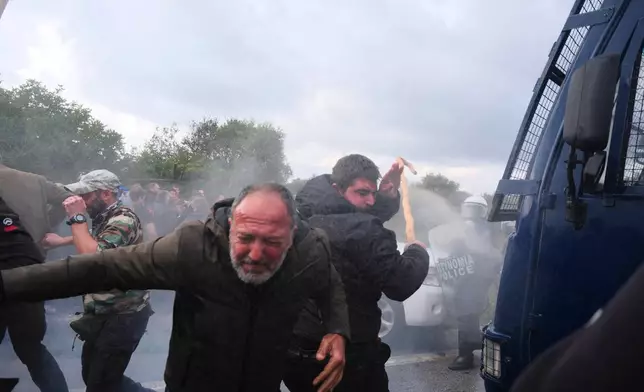 Police use tear gas against farmers during clashes with officers blocking their march to Chania's airport on Crete, Greece, Monday, Dec. 8, 2025, amid protests over delayed EU farm subsidies. (AP Photo/Giannis Angelakis)