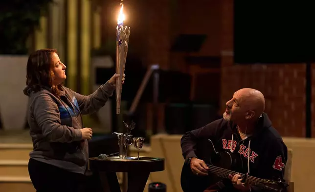 Rabbi Jonathan Aaron plays guitar while Cantor Lizzie Weiss helps during the Havdalah candle ceremony at the conclusion of a sound bath at Temple Emanuel, Saturday, Dec. 6, 2025, in Beverly Hills, Calif. (AP Photo/Allison Dinner)