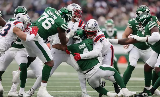 New England Patriots defensive tackle Jeremiah Pharms Jr., center right, sacks New York Jets quarterback Brady Cook, center left, during the second half of an NFL football game, Sunday, Dec. 28, 2025, in East Rutherford, N.J. (AP Photo/Adam Hunger)