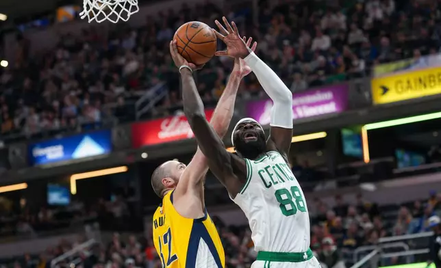 Boston Celtics center Neemias Queta (88) looks to shoot around Indiana Pacers center Jay Huff, left, during the first half of an NBA basketball game in Indianapolis, Friday, Dec. 26, 2025. (AP Photo/AJ Mast)