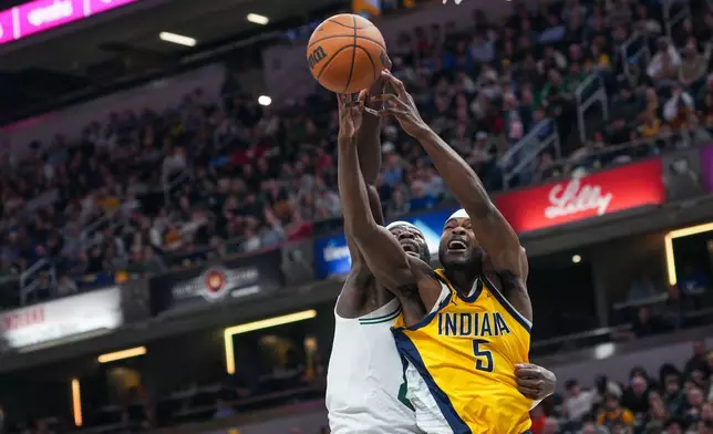Indiana Pacers forward Jarace Walker, right, battles for a rebound with Boston Celtics center Neemias Queta, left, during the first half of an NBA basketball game in Indianapolis, Friday, Dec. 26, 2025. (AP Photo/AJ Mast)