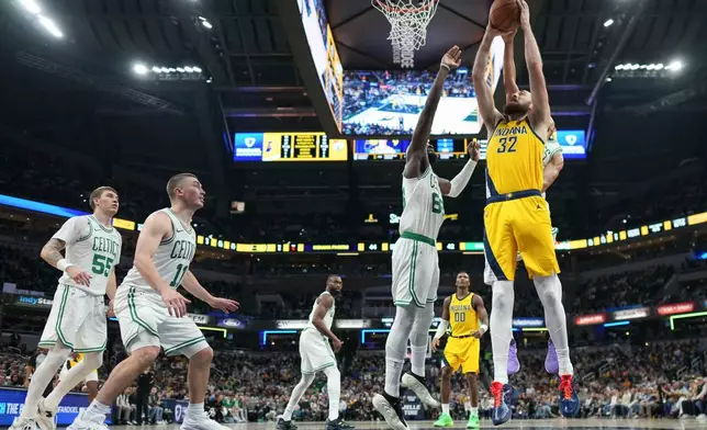 Indiana Pacers center Jay Huff, front right, goes up to shoot in front of Boston Celtics center Neemias Queta, second from front right, during the first half of an NBA basketball game in Indianapolis, Friday, Dec. 26, 2025. (AP Photo/AJ Mast)