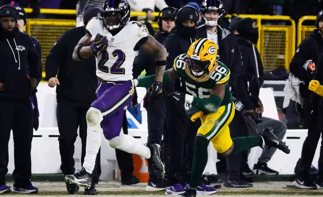 Baltimore Ravens running back Derrick Henry (22) runs the ball past Green Bay Packers linebacker Edgerrin Cooper (56) during the second half of an NFL football game, Saturday, Dec. 27, 2025, in Green Bay, Wis. (AP Photo/Mike Roemer)