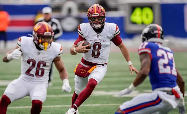 Washington Commanders quarterback Marcus Mariota (8) carries the ball against the New York Giants during the first quarter of an NFL football game, Sunday, Dec. 14, 2025, in East Rutherford, N.J. (AP Photo/Seth Wenig)