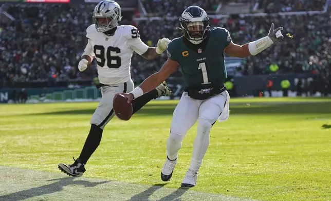 Las Vegas Raiders defensive tackle Jonah Laulu (96) forces Philadelphia Eagles quarterback Jalen Hurts (1) out of bounds during the first half of an NFL football game Sunday, Dec. 14, 2025, in Philadelphia. (AP Photo/Matt Rourke)