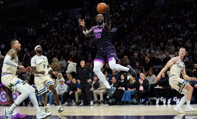 Minnesota Timberwolves forward Julius Randle shoots during the first half of an NBA basketball game against the Milwaukee Bucks, Sunday, Dec. 21, 2025, in Minneapolis. (AP Photo/Abbie Parr)