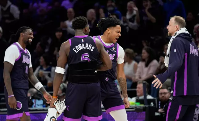Minnesota Timberwolves guard Terrence Shannon Jr. (1), back, celebrates after making a 3-point shot during the second half of an NBA basketball game against the Milwaukee Bucks, Sunday, Dec. 21, 2025, in Minneapolis. (AP Photo/Abbie Parr)