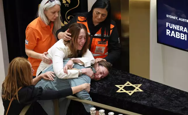 Relatives of Rabbi Eli Schlanger, who was killed in the Bondi shootings, react over his coffin during his funeral at Synagogue in Bondi, Sydney, Wednesday, Dec.17, 2025. (Hollie Adams/Pool Photo via AP)