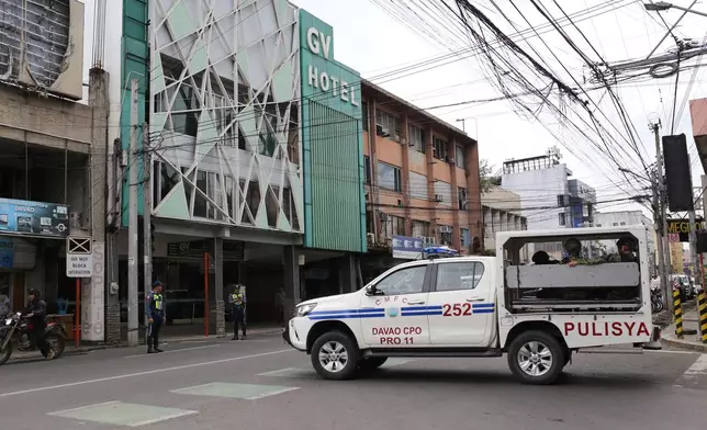 A police vehicle passes by a budget hotel in downtown Davao City, southern Philippines on Wednesday Dec. 17, 2025, as they assist investigations on where Bondi beach suspects reportedly stayed while in the country in November. (AP Photo/Manman Dejeto)