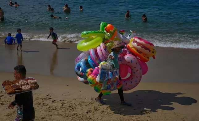 A vendor sells inflatables on Macuto beach in Venezuela, Wednesday, Dec. 17, 2025. (AP Photo/Ariana Cubillos)