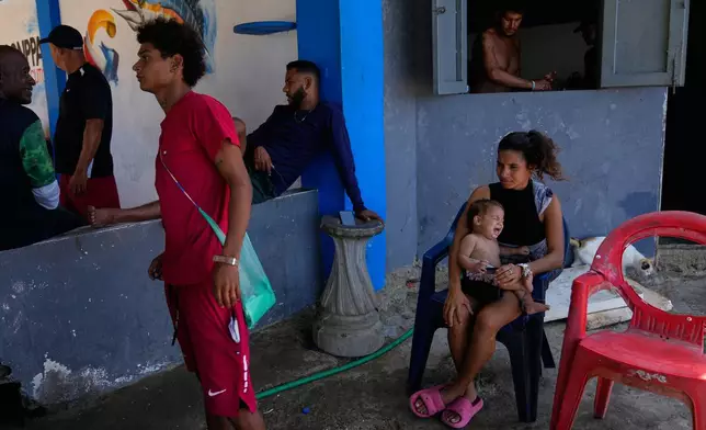 Residents and fisherman stand near Macuto beach in Venezuela, Wednesday, Dec. 17, 2025. (AP Photo/Ariana Cubillos)