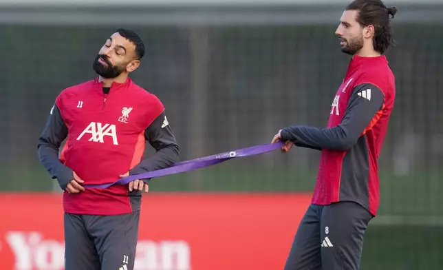 Liverpool's Mohamed Salah, left, uses a resistance band with teammate Dominik Szoboszlai as they take part in a training session in Liverpool, England, Monday, Dec. 8, 2025. (AP Photo/Jon Super)