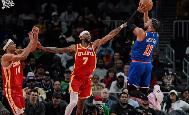 New York Knicks guard Jalen Brunson (11) shoots against Atlanta Hawks guard Nickeil Alexander-Walker (7) during the first half of an NBA basketball game, Saturday, Dec. 27, 2025, in Atlanta. (AP Photo/Mike Stewart)