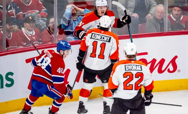 Philadelphia Flyers' Trevor Zegras (46) celebrates his goal with teammates Travis Konecny (11) Christian Dvorak (22) during second period NHL hockey action against the Montreal Canadiens in Montreal on Tuesday, Dec. 16, 2025. (Christopher Katsarov/The Canadian Press via AP)