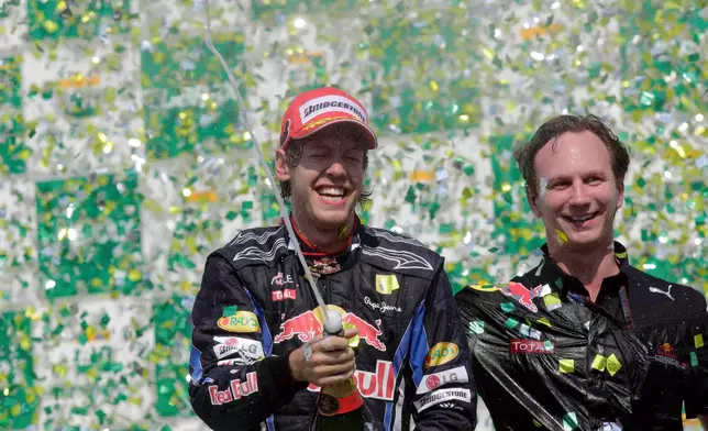 FILE - First place Red Bull driver Sebastian Vettel, of Germany, celebrates as Red Bull team principal Christian Horner looks on at the podium after winning Brazil's Formula One Grand Prix at the Interlagos race track in Sao Paulo, Brazil, Nov. 7, 2010. (AP Photo/Luca Bruno, File)