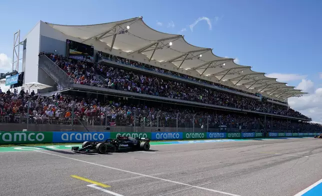 Mercedes driver Lewis Hamilton, of Britain, races past the grand stand followed by Red Bull driver Max Verstappen, of the Netherlands, during for the F1 U.S. Grand Prix auto race at the Circuit of the Americas, Oct. 24, 2021, in Austin, Texas. (AP Photo/Darron Cummings, Pool)