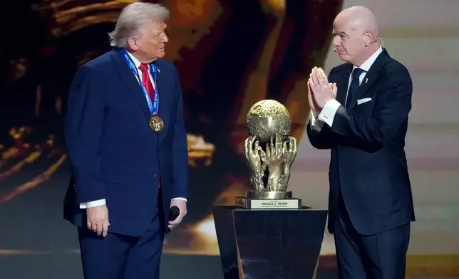 FIFA President Gianni Infantino, right, awards President Donald Trump with the FIFA Peace Prize during the draw for the 2026 soccer World Cup at the Kennedy Center in Washington, Friday, Dec. 5, 2025. (AP Photo/Chris Carlson)