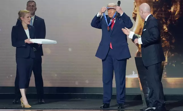 President Donald Trump is presented with the inaugural FIFA Peace Prize by FIFA President Gianni Infantino during the 2026 FIFA World Cup draw at the Kennedy Center, Friday, Dec. 5, 2025, in Washington. (AP Photo/Evan Vucci)