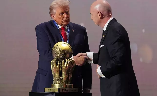 President Donald Trump receives the FIFA Peace Prize from FIFA President Gianni Infantino during the draw for the 2026 soccer World Cup at the Kennedy Center in Washington, Friday, Dec. 5, 2025. (AP Photo/Jacquelyn Martin)