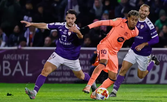 Barcelona's Lamine Yamal, center, vies for the ball with Guadalajara's Manu Ramirez during the Copa del Rey soccer match between Guadalajara and Barcelona in Guadalajara, Spain, Tuesday, Dec. 16, 2025. (AP Photo/Rudy Garcia)
