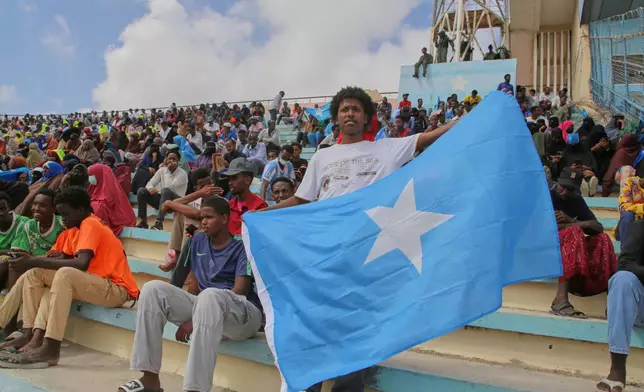 A man holds the flag of Somalia as people gather at the Mogadishu stadium while they protest Israel's recognition of Somalia's breakaway region of Somaliland as an independent nation, in Mogadishu, Somalia, Tuesday, Dec. 30, 2025. (AP photo/Farah Abdi Warsameh)
