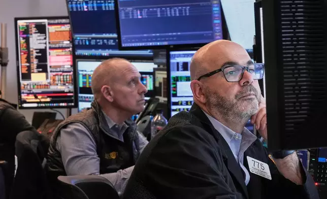 Traders Michael Urkonis, left, and Fred Demarco work on the floor of the New York Stock Exchange, Tuesday, Dec. 2, 2025. (AP Photo/Richard Drew)