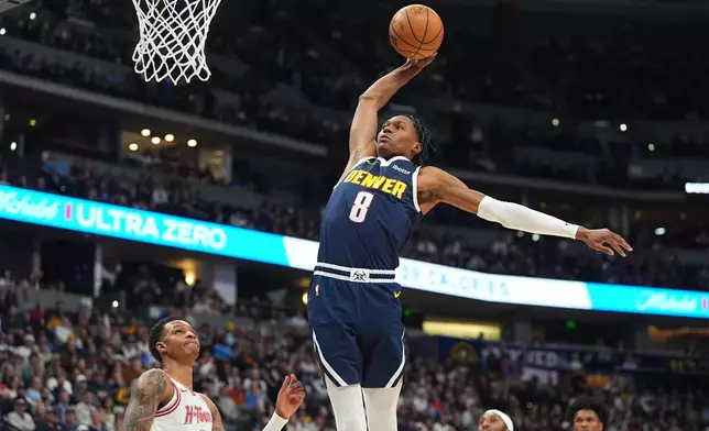 Denver Nuggets guard Peyton Watson (8) goes up to dunk over Houston Rockets forward Jabari Smith Jr., left, in the first half of an NBA basketball game Monday, Dec. 15, 2025, in Denver. (AP Photo/David Zalubowski)