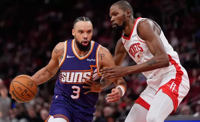 Phoenix Suns forward Dillon Brooks (3) controls the ball against Houston Rockets forward Kevin Durant (7) during the first half of an NBA basketball game in Houston, Friday, Dec. 5, 2025. (AP Photo/Ashley Landis)