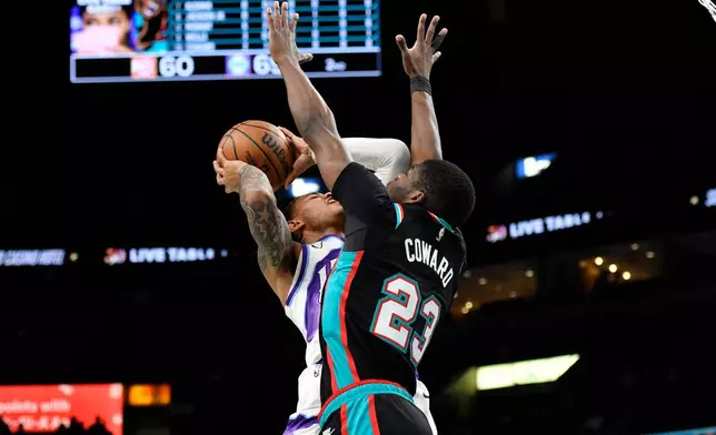 Utah Jazz guard Keyonte George, left, shoots against Memphis Grizzlies forward Cedric Coward (23) in the first half of an NBA basketball game Friday, Dec. 12, 2025, in Memphis, Tenn. (AP Photo/Brandon Dill)