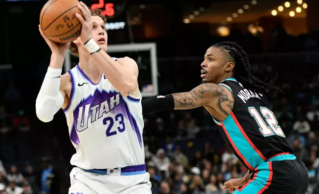 Utah Jazz forward Lauri Markkanen (23) handles the ball against Memphis Grizzlies guard Ja Morant (12) in the first half of an NBA basketball game Friday, Dec. 12, 2025, in Memphis, Tenn. (AP Photo/Brandon Dill)