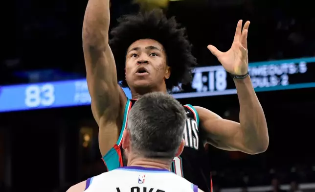 Memphis Grizzlies forward Jaylen Wells, top, shoots over Utah Jazz forward Kevin Love (42) in the second half of an NBA basketball game Friday, Dec. 12, 2025, in Memphis, Tenn. (AP Photo/Brandon Dill)
