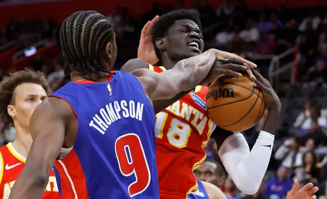 Atlanta Hawks forward Mouhamed Gueye (18) is defended by Detroit Pistons guard Ausar Thompson (9) while going to the basket during the first half of an NBA basketball game Friday, Dec. 12, 2025, in Detroit. (AP Photo/Duane Burleson)